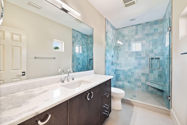 bathroom with tile patterned flooring, vanity, a shower with door, and toilet