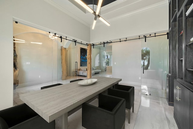 dining room featuring crown molding and a barn door