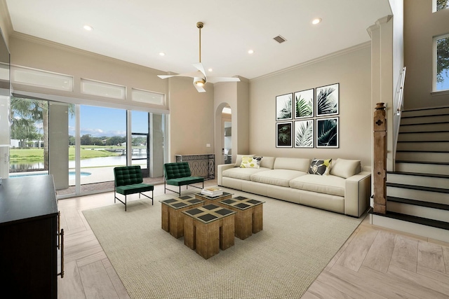 living room with crown molding, light parquet floors, and a water view