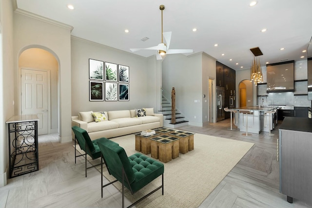 living room with crown molding, ceiling fan, sink, and light parquet floors