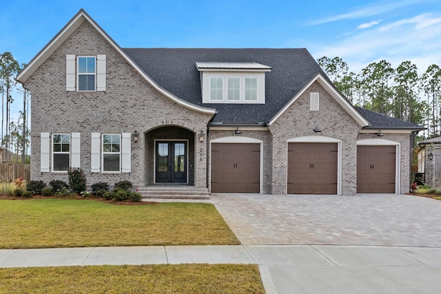 view of front of house with french doors, a front yard, and a garage