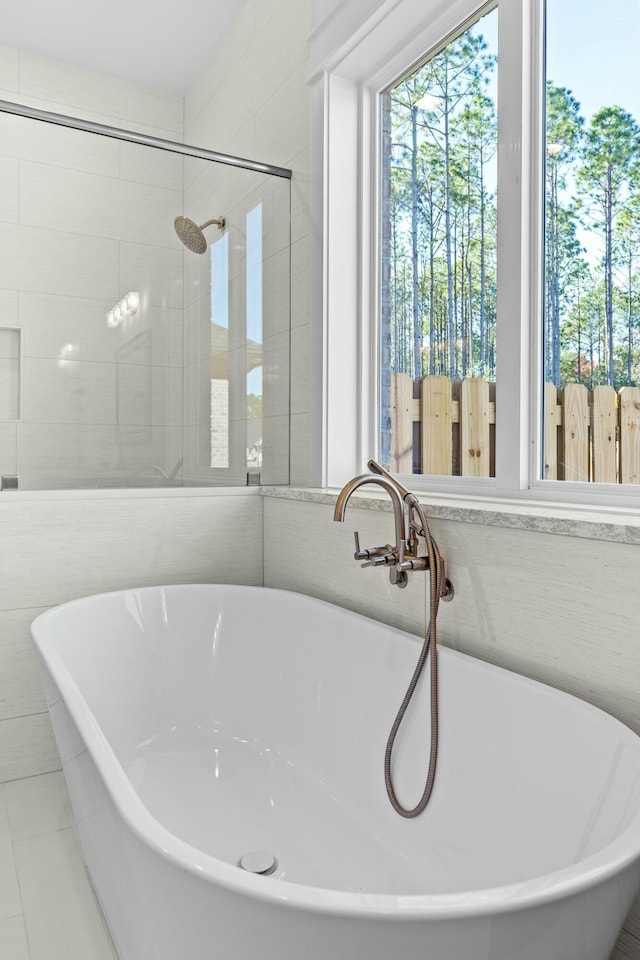 bathroom featuring shower with separate bathtub