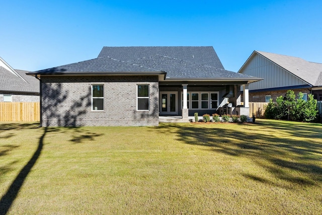 rear view of property with a lawn