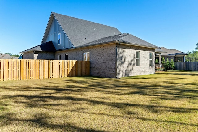 rear view of house featuring a lawn