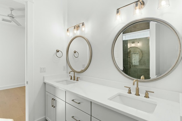 bathroom with vanity, ceiling fan, and a shower with shower door