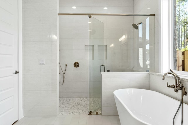 bathroom with tile patterned floors, sink, and plus walk in shower