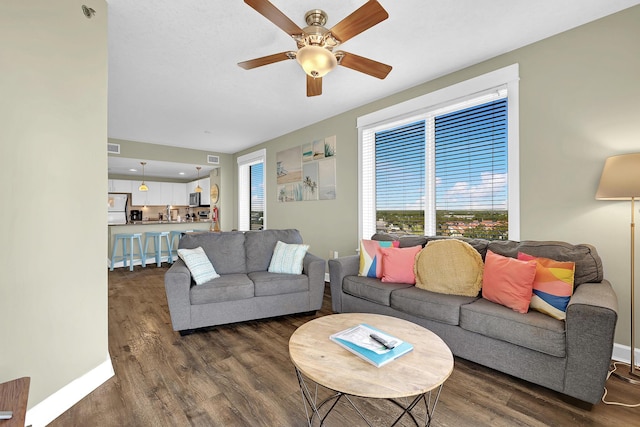 living room with dark hardwood / wood-style flooring and ceiling fan