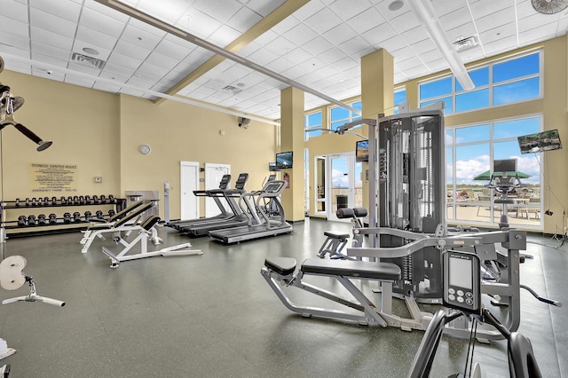 workout area featuring a drop ceiling and a high ceiling