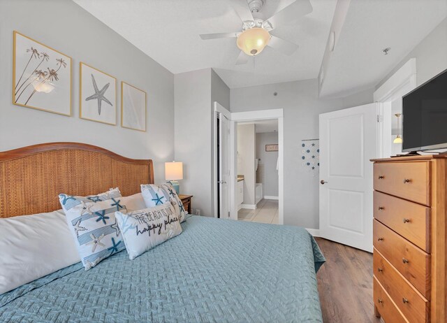 bedroom featuring hardwood / wood-style flooring, ceiling fan, and connected bathroom