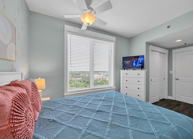 bedroom with ceiling fan, dark hardwood / wood-style flooring, and a closet