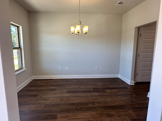 unfurnished room featuring dark hardwood / wood-style floors and a notable chandelier