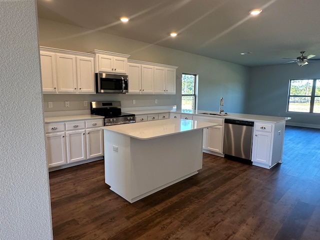 kitchen featuring kitchen peninsula, white cabinetry, sink, and appliances with stainless steel finishes