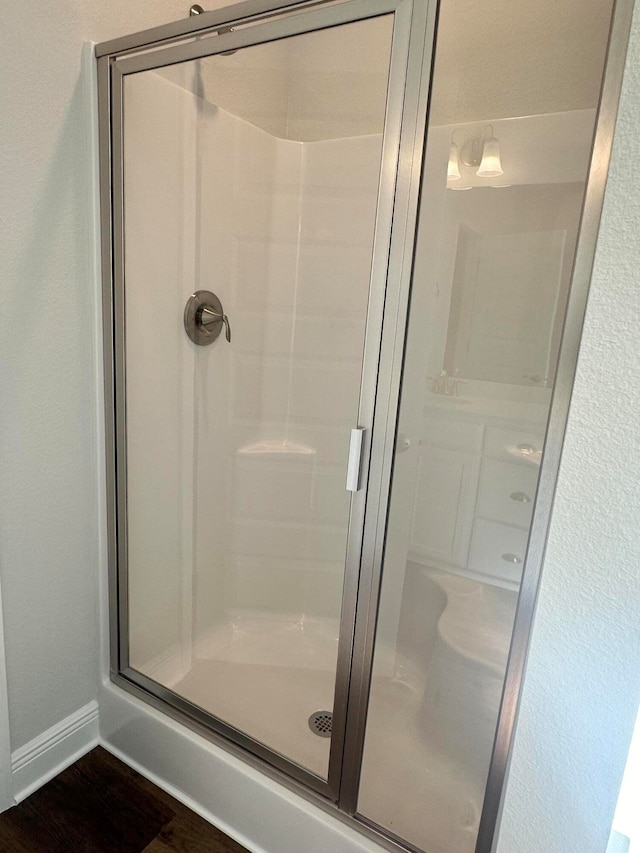 bathroom featuring wood-type flooring and walk in shower