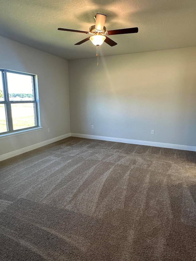 carpeted empty room featuring ceiling fan and a textured ceiling