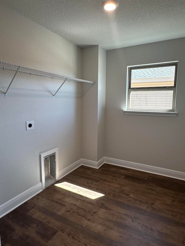 clothes washing area featuring hookup for an electric dryer, dark hardwood / wood-style flooring, and a textured ceiling