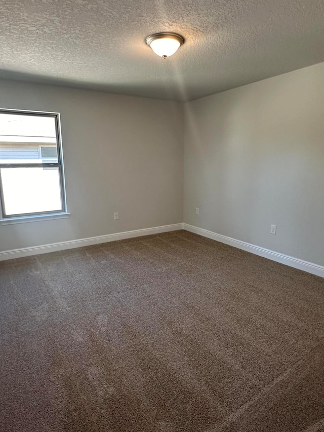 carpeted spare room featuring a textured ceiling