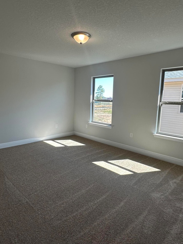 carpeted spare room with a textured ceiling