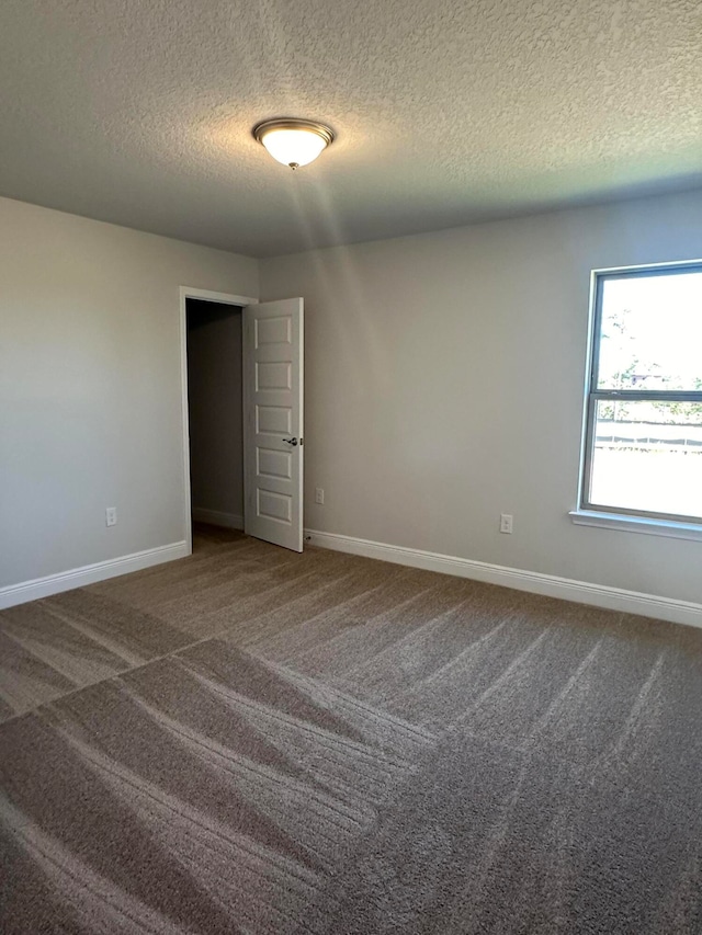 carpeted spare room with a textured ceiling