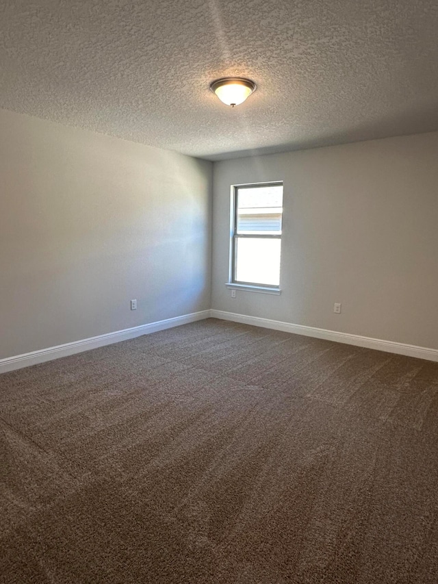 carpeted empty room featuring a textured ceiling