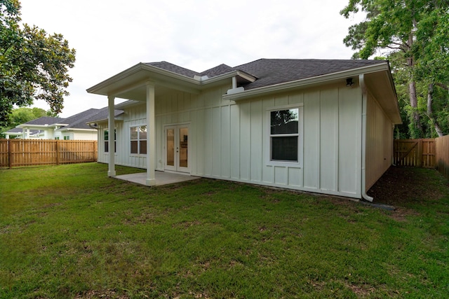 rear view of property with french doors, a patio, and a lawn