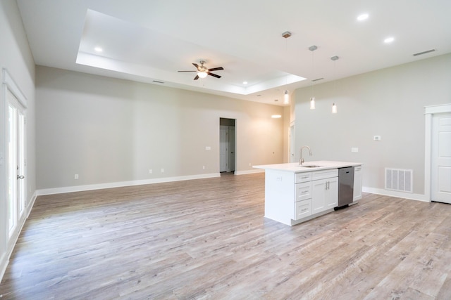 kitchen with pendant lighting, white cabinets, ceiling fan, a tray ceiling, and light hardwood / wood-style floors