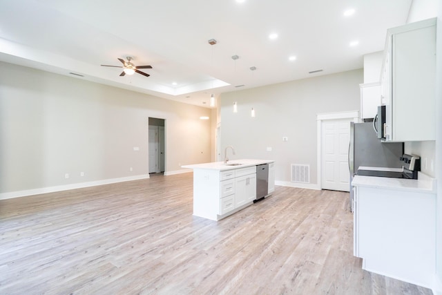 kitchen featuring white cabinetry, hanging light fixtures, light hardwood / wood-style floors, a kitchen island with sink, and appliances with stainless steel finishes