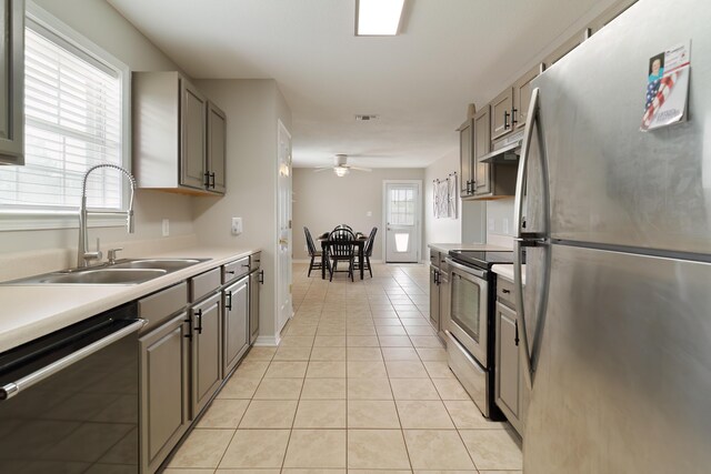 kitchen with ceiling fan, sink, light tile patterned floors, and appliances with stainless steel finishes