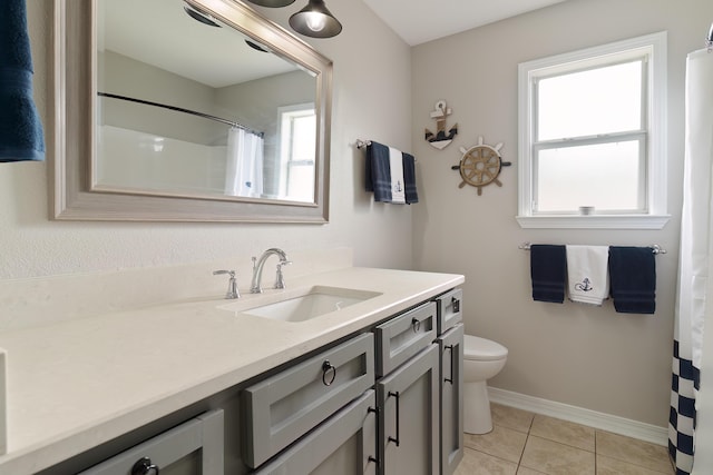 bathroom featuring a wealth of natural light, tile patterned flooring, vanity, and toilet