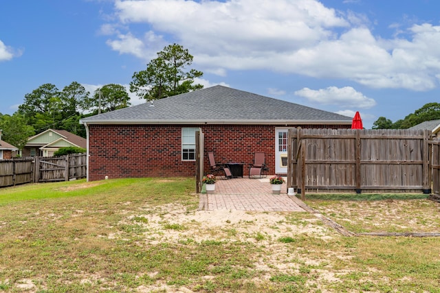 back of house with a yard and a patio