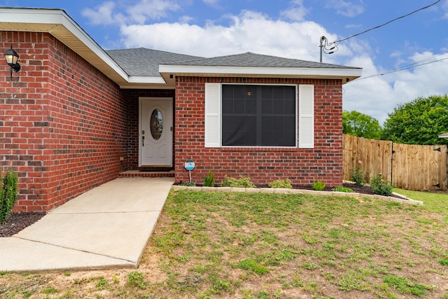 doorway to property featuring a lawn