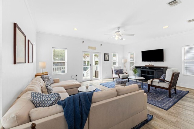 living room featuring french doors, light wood-type flooring, ceiling fan, and crown molding