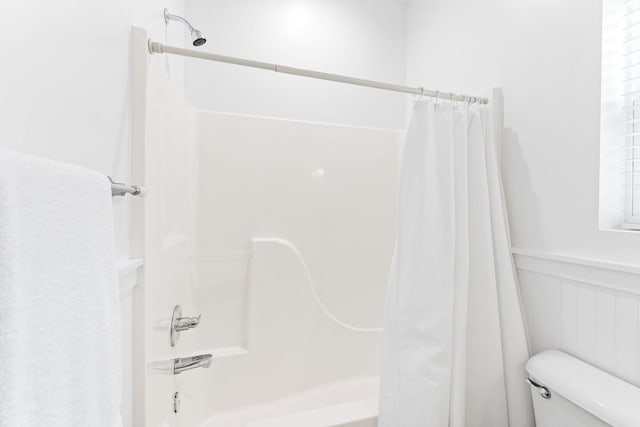 bathroom featuring shower / bath combo with shower curtain and toilet