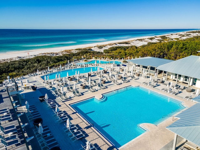 view of swimming pool featuring a view of the beach and a water view