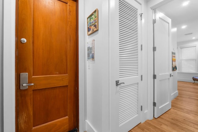 corridor with light hardwood / wood-style floors