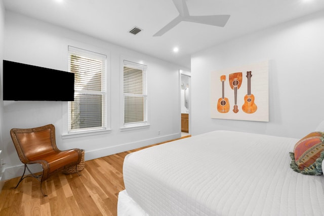 bedroom featuring ensuite bathroom, light wood-type flooring, and ceiling fan