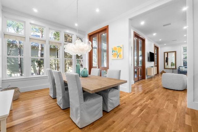 dining area featuring ornamental molding, light hardwood / wood-style flooring, and plenty of natural light