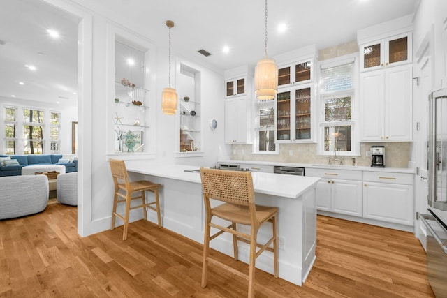 kitchen with a kitchen breakfast bar, white cabinetry, and kitchen peninsula