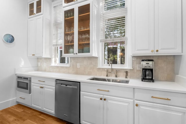 kitchen featuring white cabinets, wall oven, dishwasher, and sink