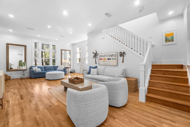 living room with ornamental molding and light hardwood / wood-style floors