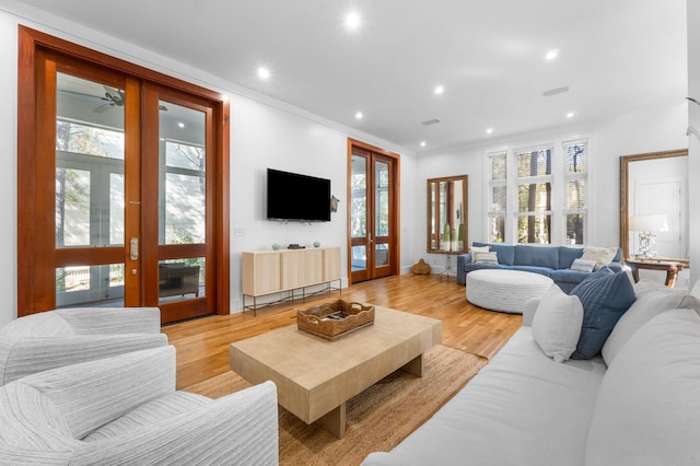 living room with french doors, light wood-type flooring, and plenty of natural light