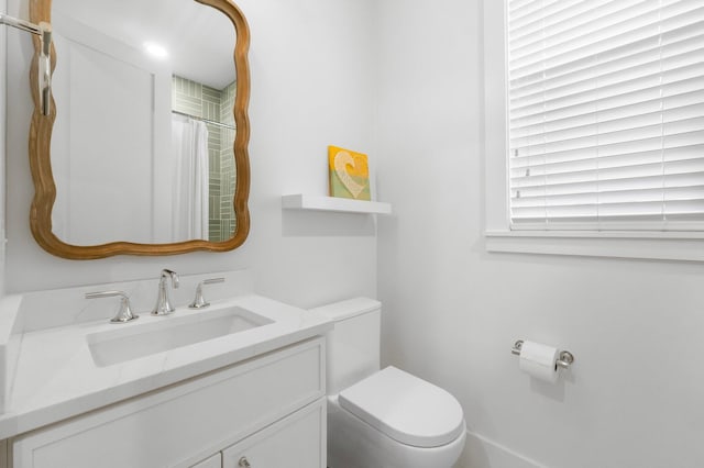 bathroom with toilet, curtained shower, and vanity