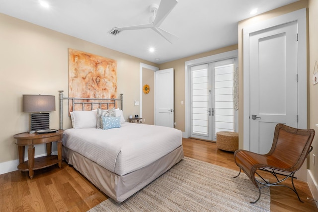 bedroom with ceiling fan, light hardwood / wood-style floors, and french doors