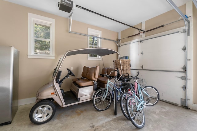 garage featuring stainless steel refrigerator and a garage door opener