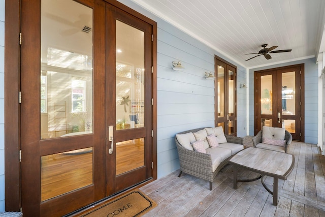 wooden deck featuring ceiling fan and french doors