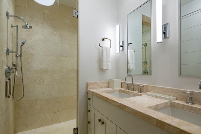 bathroom featuring dual vanity and tiled shower