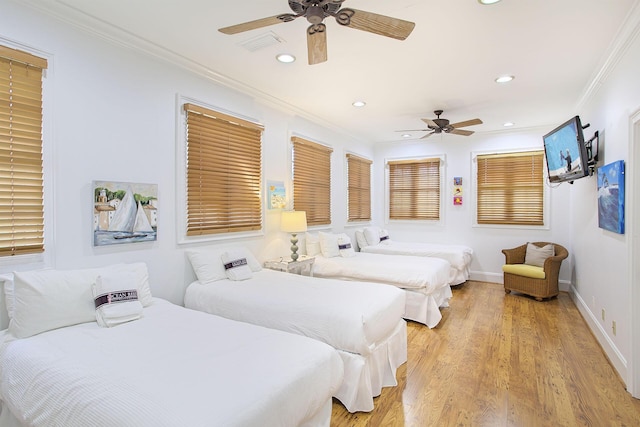 bedroom with crown molding, ceiling fan, and light hardwood / wood-style flooring