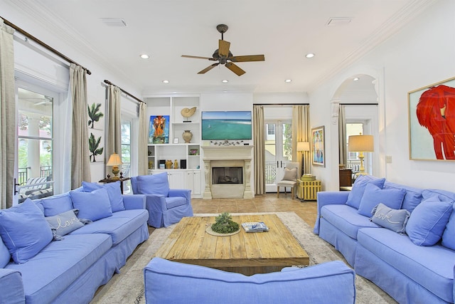 living room with ceiling fan, ornamental molding, and built in shelves