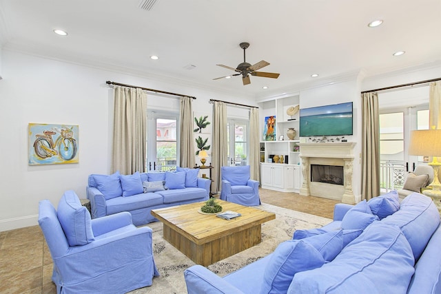 living room with built in features, crown molding, ceiling fan, and a premium fireplace