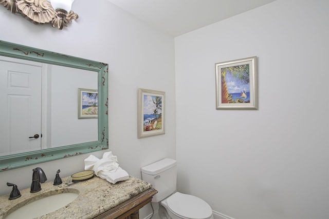 bathroom with a notable chandelier, vanity, and toilet