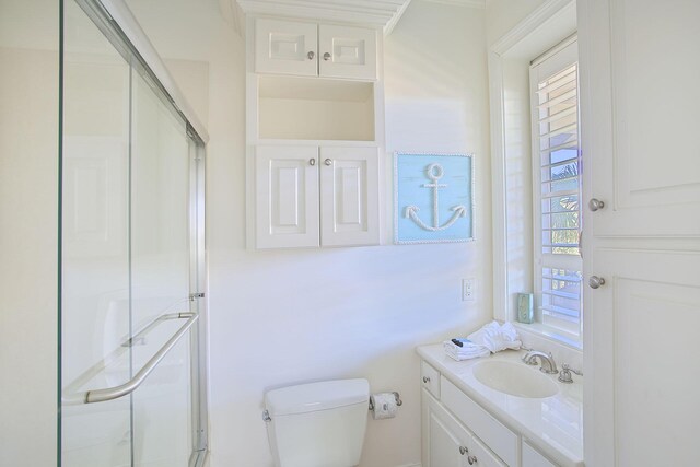 bathroom with toilet, a shower with shower door, and vanity